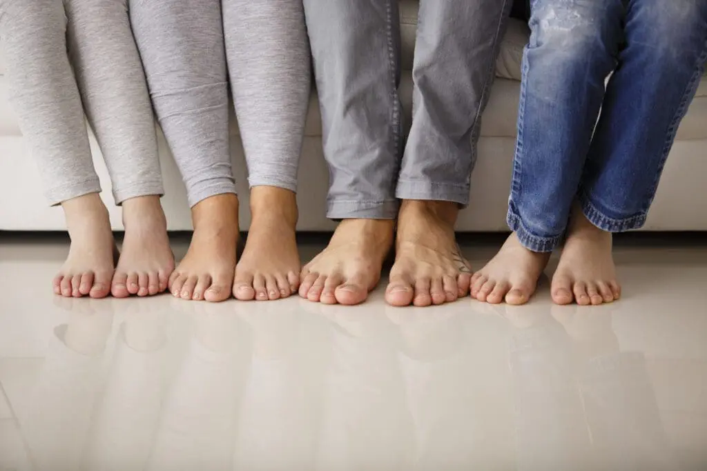 Barefoot family sitting on sofa, low section